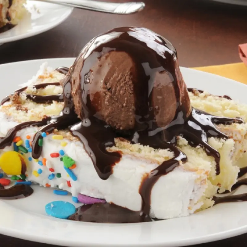 Frosted Vanilla Birthday Cake With Hot Fudge Sauce and Sprinkles